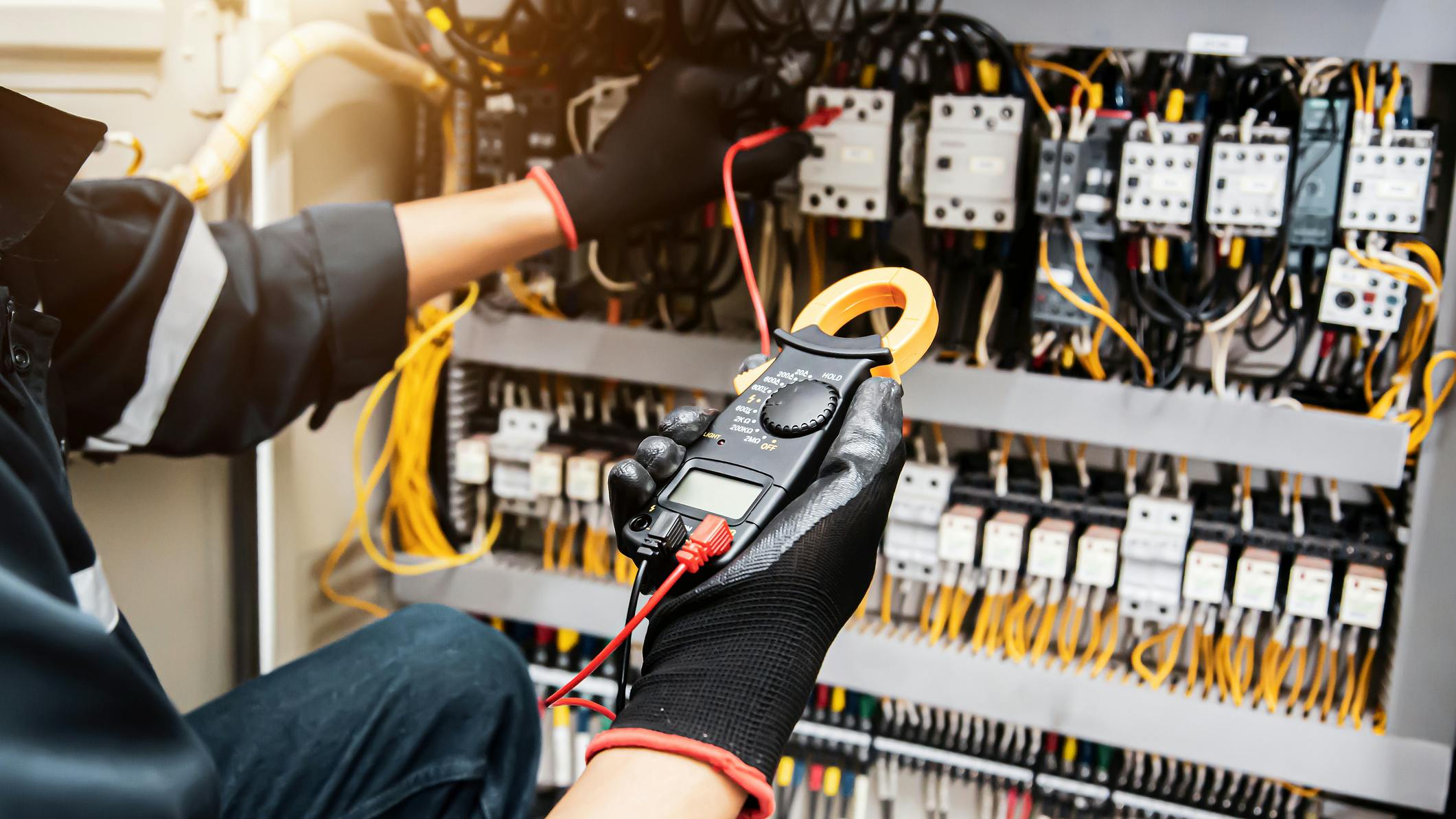 Electricity and electrical safety maintenance service system, Technician hand checking electric current voltage at circuit breaker terminal and cable wiring in main power distribution board