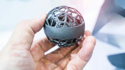 Hand holding spherical metal 3d-printed object close-up Hand holding spherical metal 3d-printed object close-up