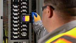 Worker inspecting electrical panel with Flir C8 thermal imaging camera Worker inspecting electrical panel with Flir C8 thermal imaging camera