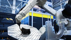 Robotic arm performs automated work on a metal part in a modern industrial factory. Robotic arm performs automated work on a metal part in a modern industrial factory.