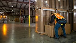 HeroWear worker wearing exosuit while lifting HeroWear worker wearing exosuit while lifting