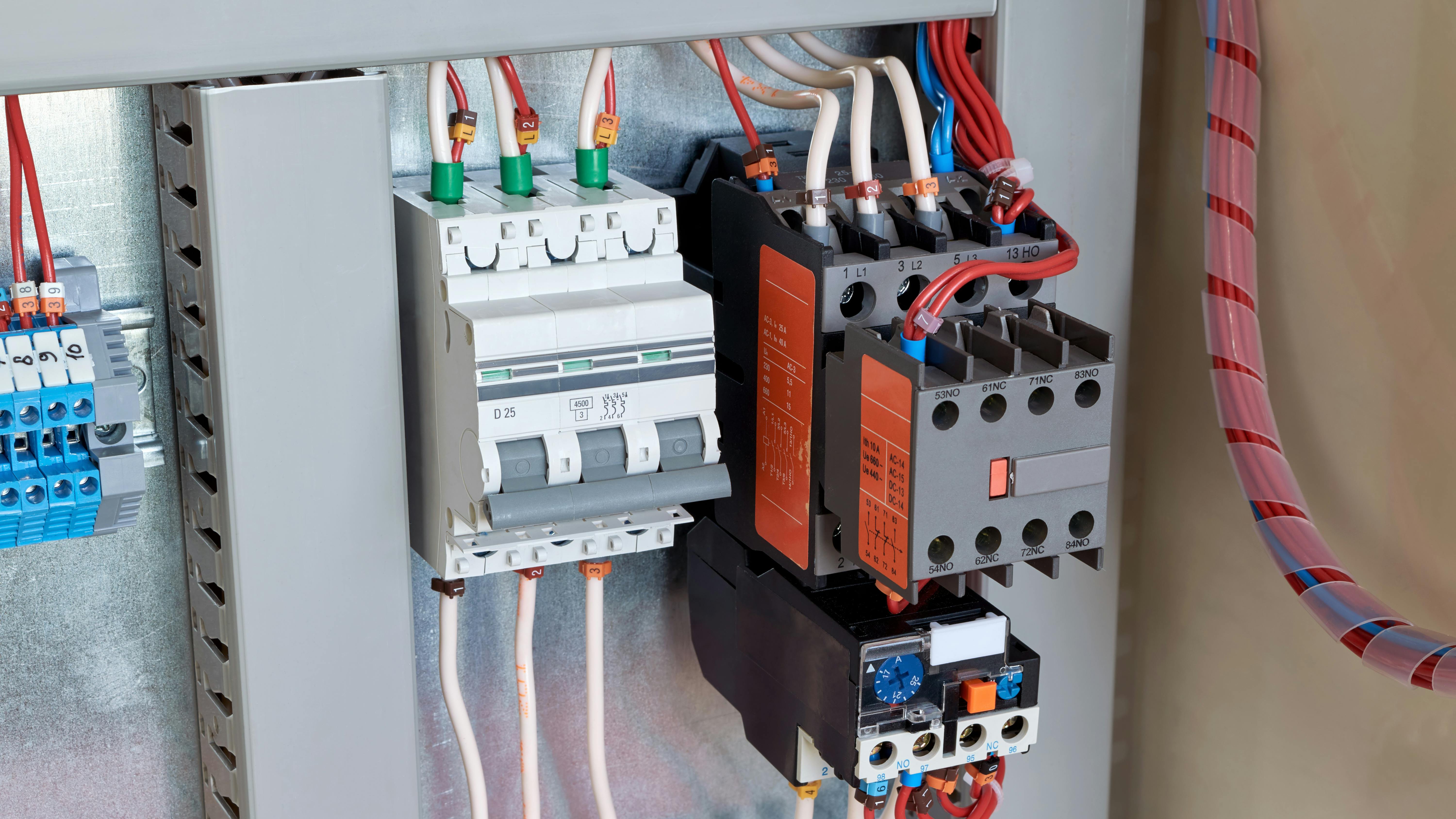 Circuit breaker, contactor, or starter with additional contacts and a thermal relay in an electrical cabinet.